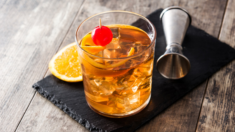 old fashioned whiskey cocktail with orange and cherry garnish