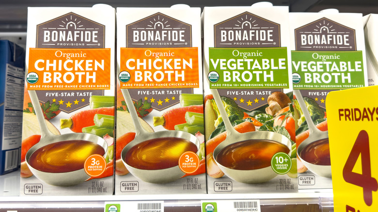 Chicken and vegetable broth boxes sit on a supermarket shelf