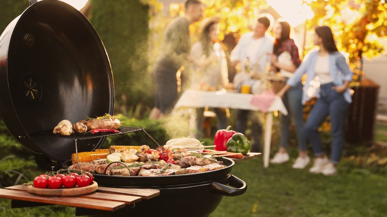 Open grill in backyard with people in background
