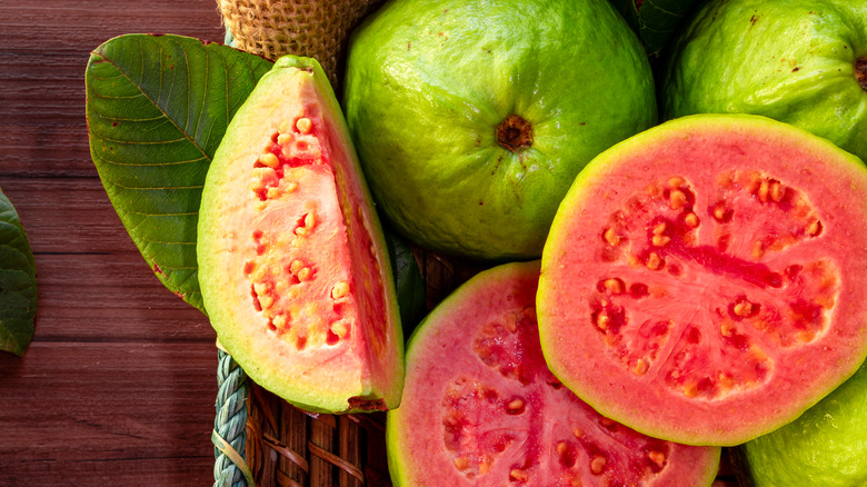 A basket of whole and sliced guavas