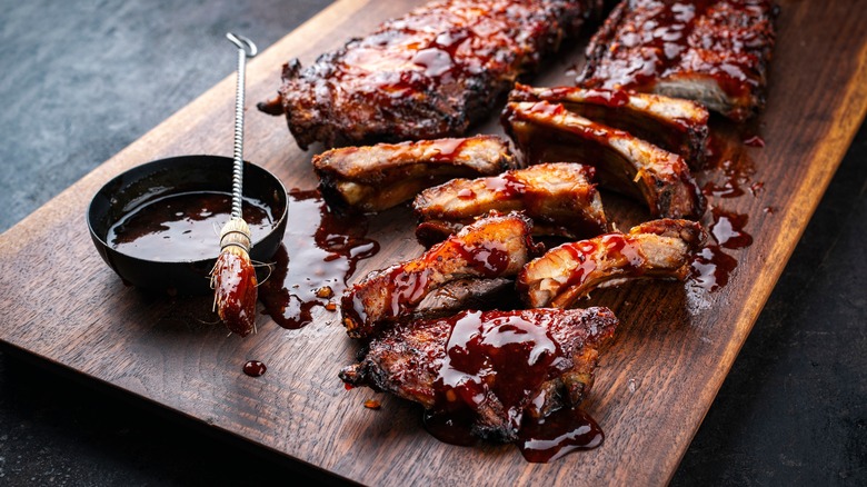 Smoked ribs with barbecue sauce on a wooden board