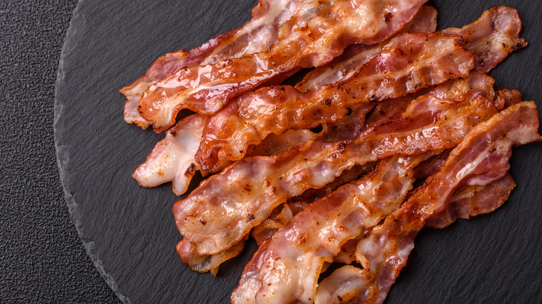 A plate of cooked streaky bacon