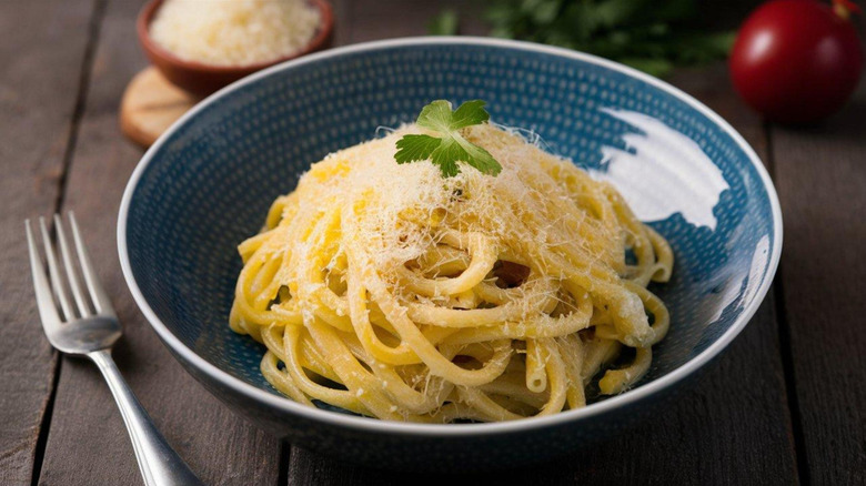 Pasta al burro in a dish topped with Parmigiano Reggiano
