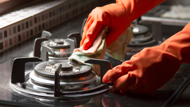 Person cleaning stove.
