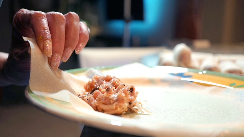 hand folding egg rolls