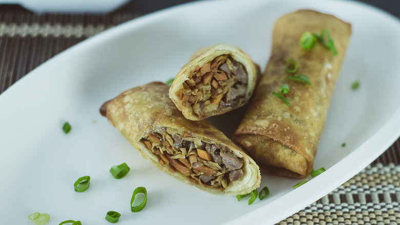 hands rolling egg rolls
