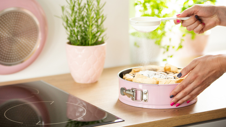 Dusting sugar over a cake in a springform pan