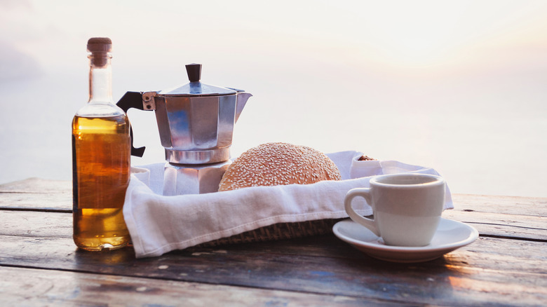 A bottle of oil next to a moka pot