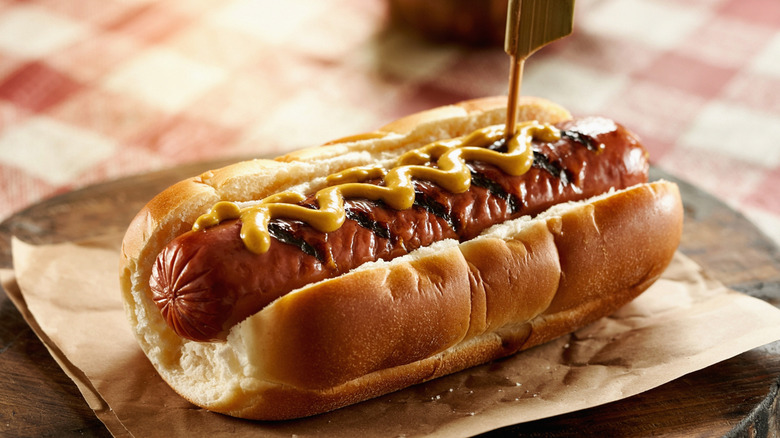 Grilled hot dog in a bun with mustard