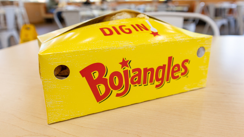 Yellow and red Bojangles box with food inside on a table.