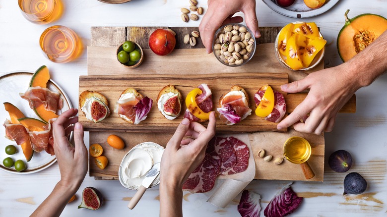 table with hands grabbing appetizers