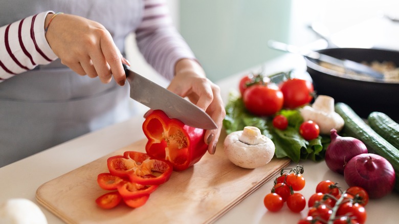 woman cutting vegetables preparing a meal