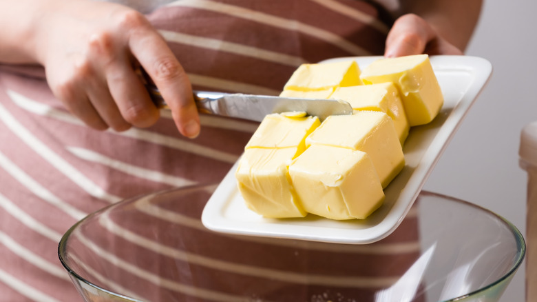 Adding butter to mixing bowl for baking