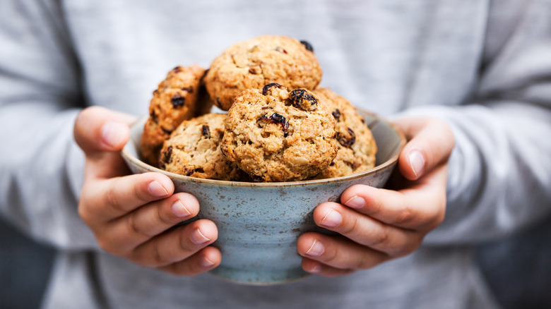 Hands holding a bowl of cookies