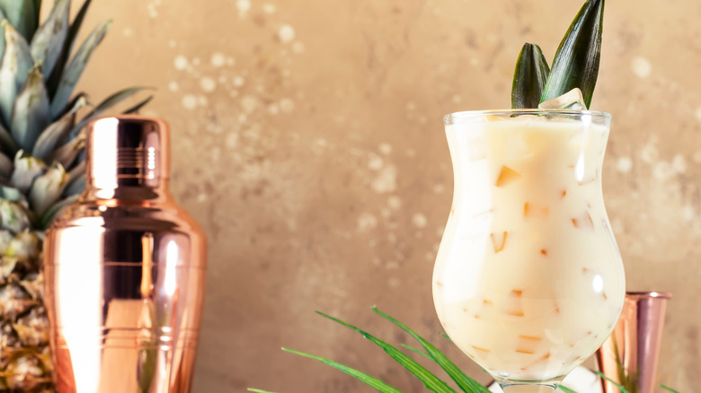 A Malibu-pineapple cocktail in a curved glass.