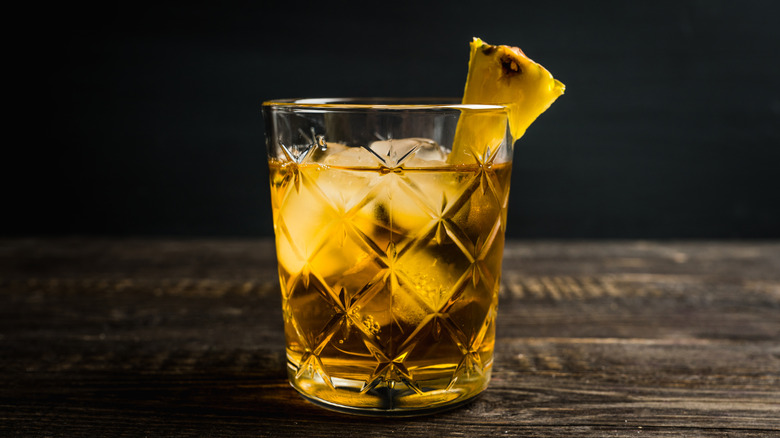 A pineapple whiskey cocktail sitting on a bar
