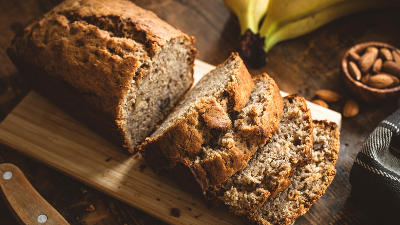 a loaf of banana bread sliced on a cutting board