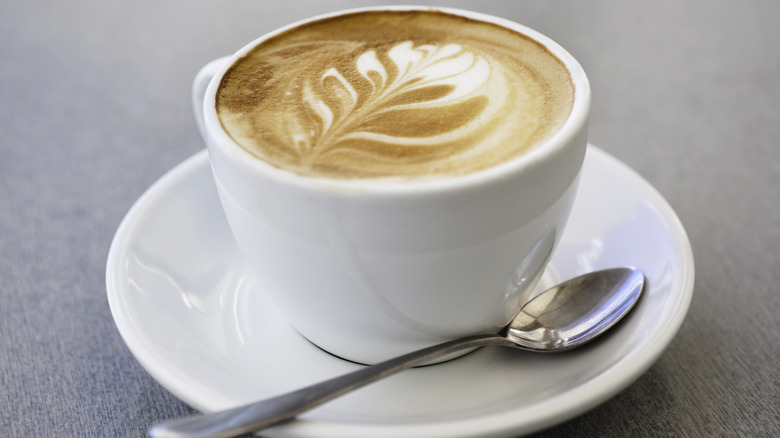 Latte coffee with foam art in ceramic cup