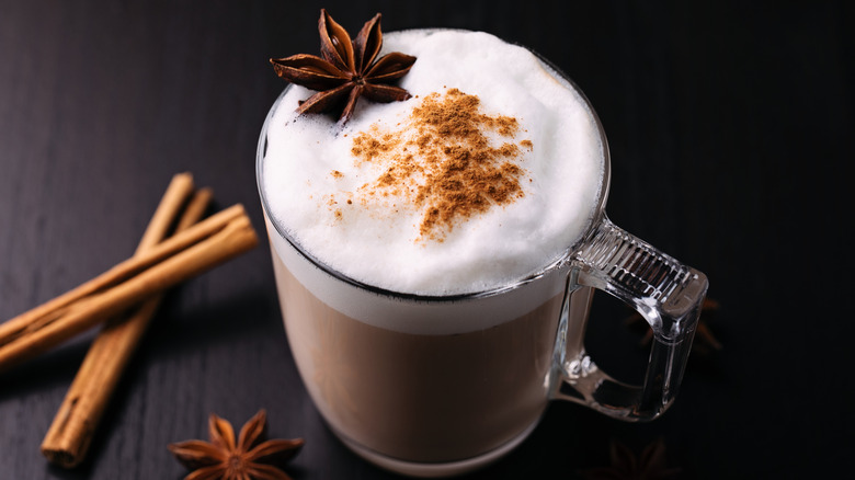 chai latte on a table topped with an anise star and cinnamon