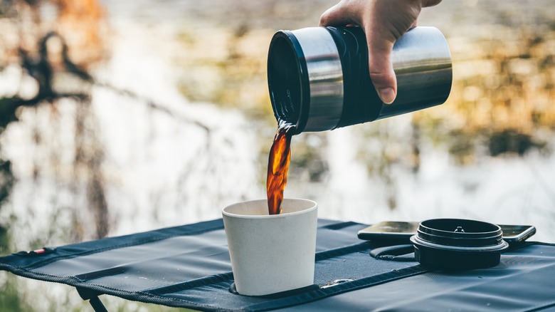 Pouring coffee from a thermos into a mug