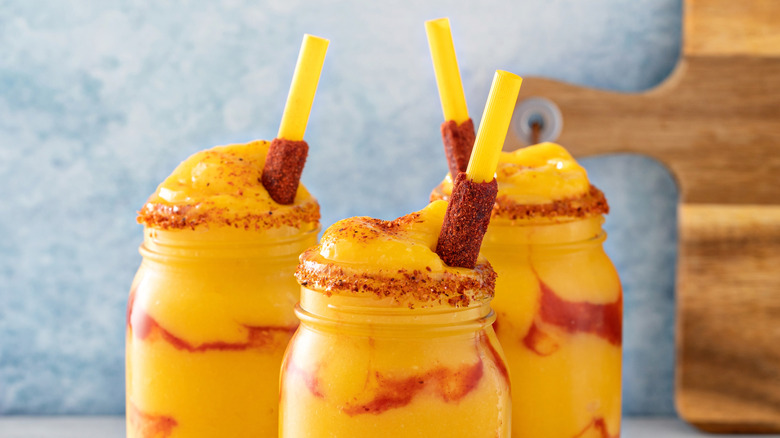 Yellow smoothies with chamoy-covered candy straws