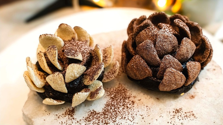 Two pinecone treats made of chocolate cake and cornflake cereal