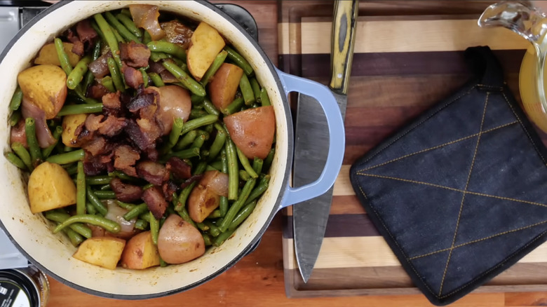 A casserole dish with green beans, bacon, and potatoes