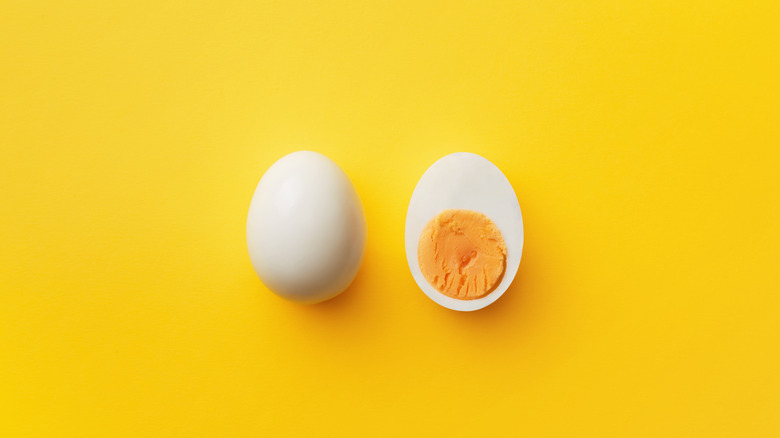 hard boiled egg on yellow background, half