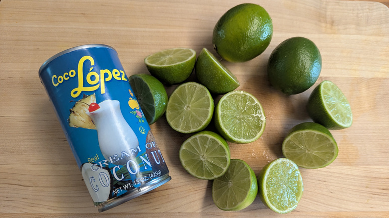 A can of Coco López cream of coconut and cut limes.