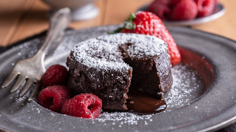 Molten chocolate lava cake dusted with powdered sugar and garnished with red berries