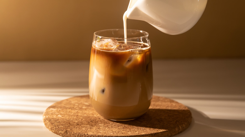 cold brew over ice with milk pouring in