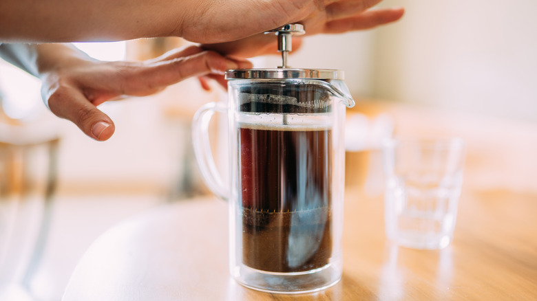 woman pressing plunger on French press