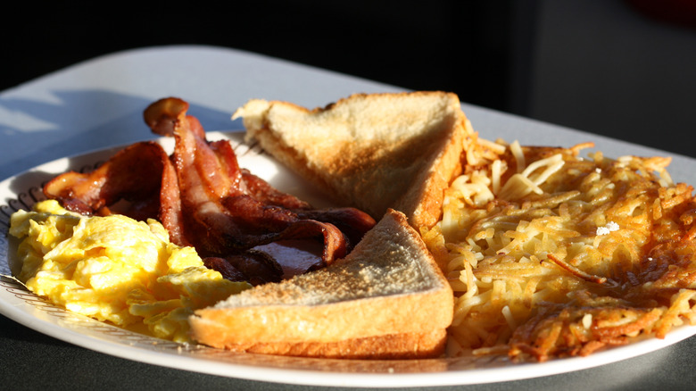 A full breakfast from Waffle House includes scrambled eggs, bacon, toast, and hashbrowns.