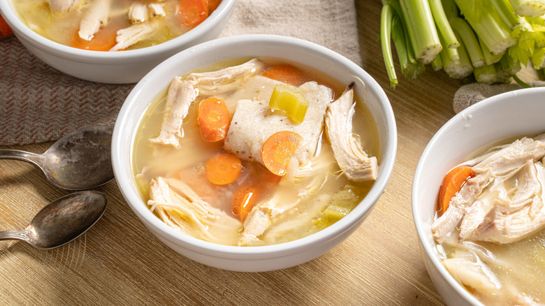 White bowls of chicken and dumplings on a table