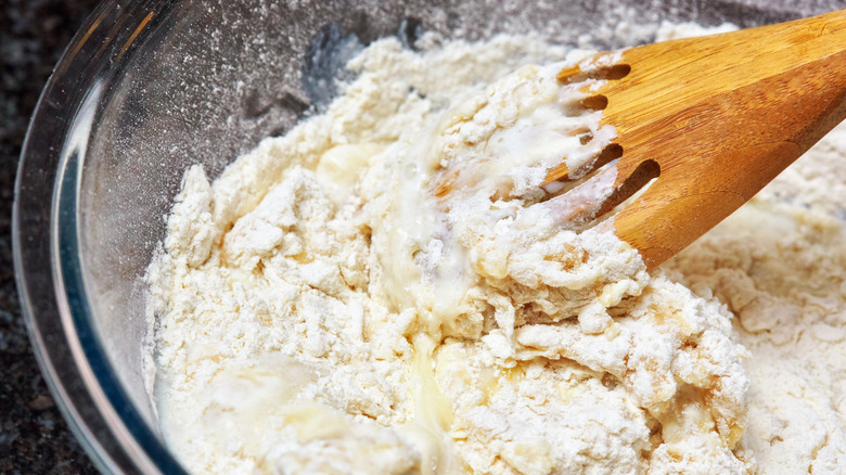 Wooden spoon mixing biscuit dough