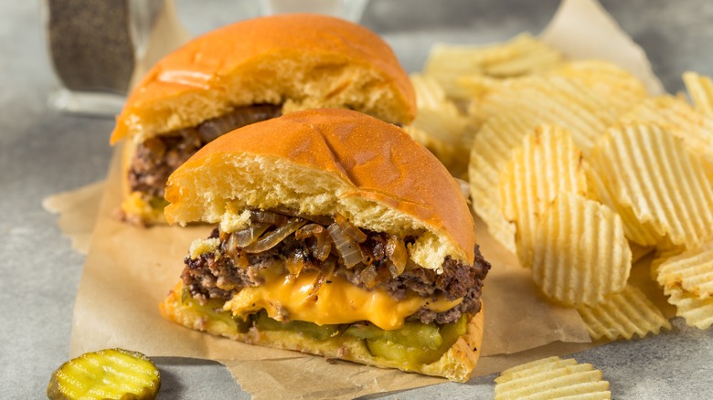 Juicy Lucy cheeseburger sliced in half served with chips 