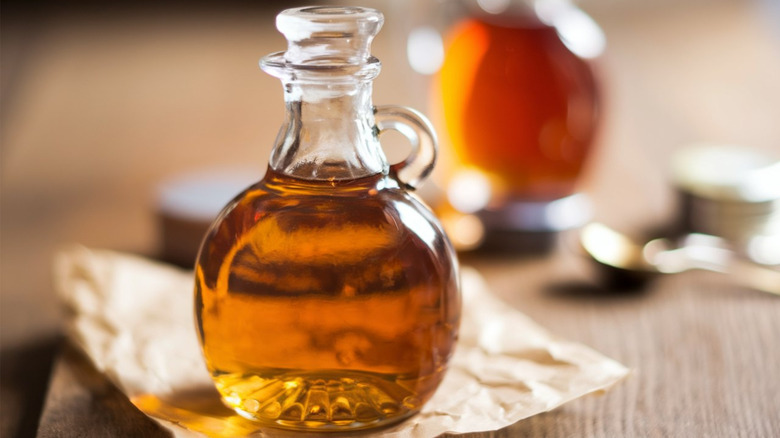 A clear, glass bottle of maple syrup