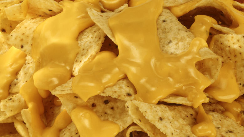 closeup of restaurant nachos with cheese sauce over them