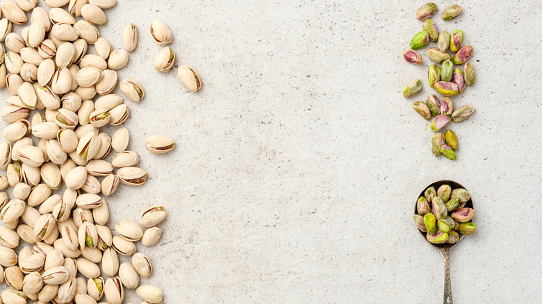 unshelled pistachios and shelled pistachios in spoon