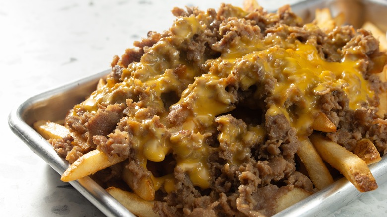 Chopped beef and cheese on top of a bed of French fries
