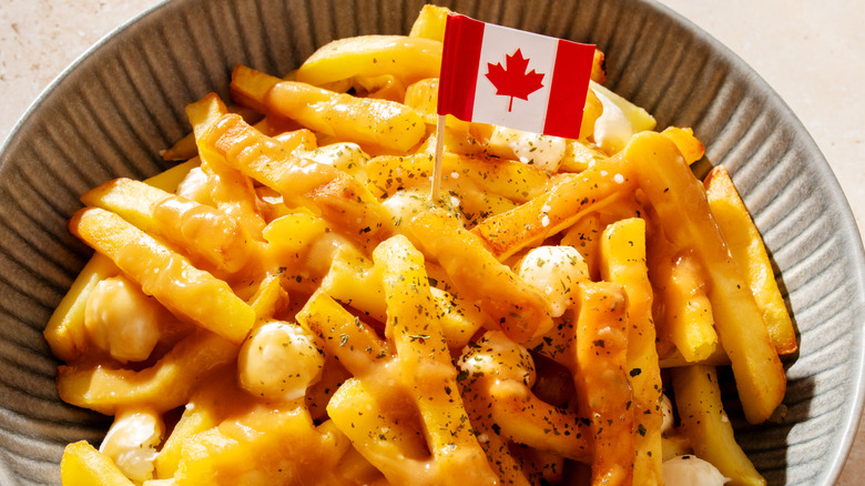 Standard Canadian poutine, topped with black pepper and a tiny Canadian flag.