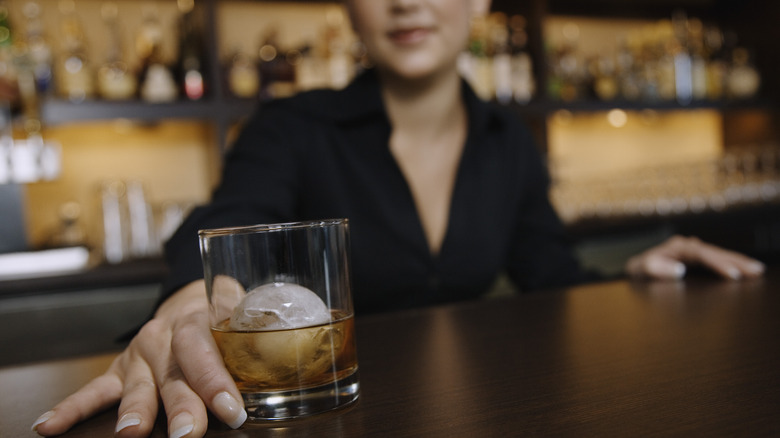 bartender serving whiskey on the rocks