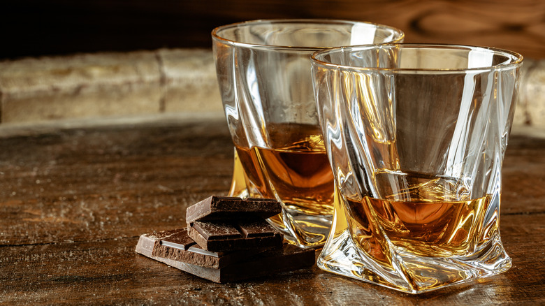 Glasses of whiskey with pieces of dark chocolate
