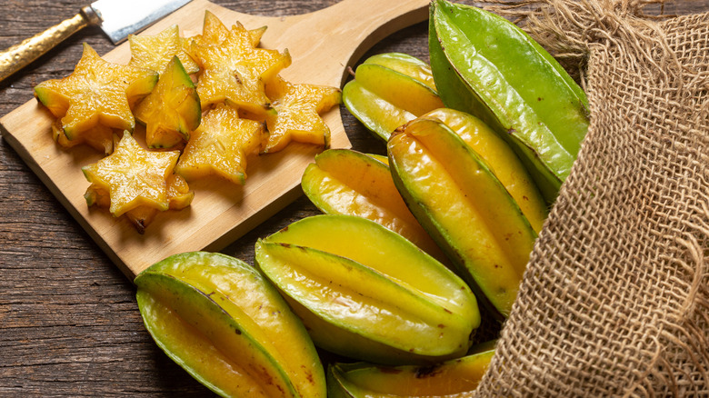 whole star fruit in bag and sliced star fruit on cutting board