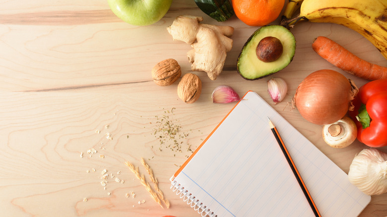 blank notebook and pencil with fruit and vegetables