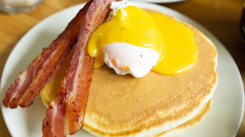 Poached eggs and bacon on pancakes