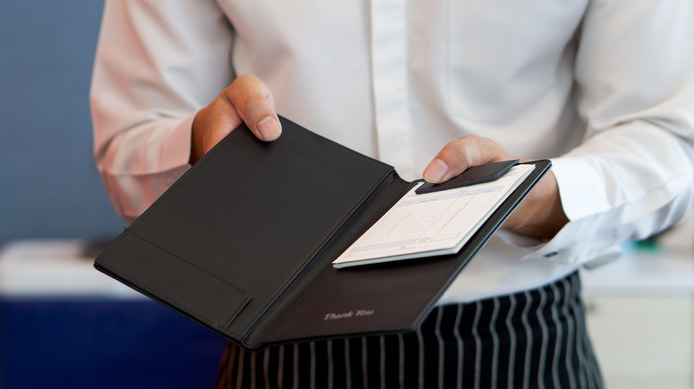 waiter presenting bill at restaurant