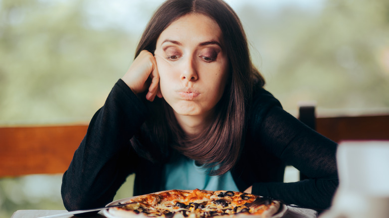 Disappointed person looking at pizza