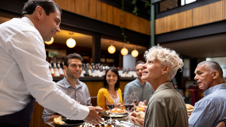Server interacting with restaurant guests