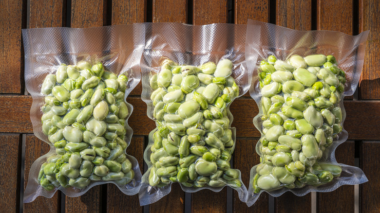 Three airtight bags of beans on wood table